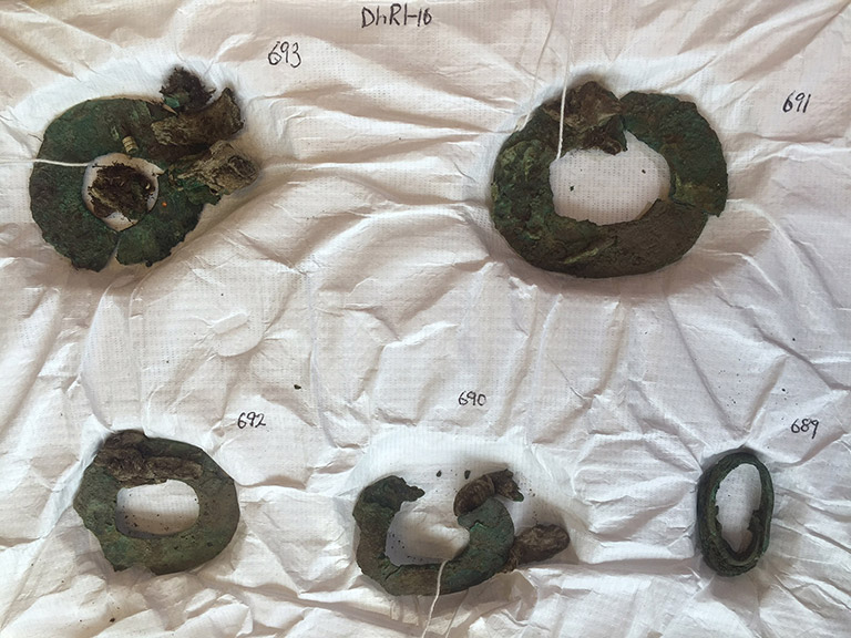 Five oxidized metal hoops, three small ones and two large ones.
