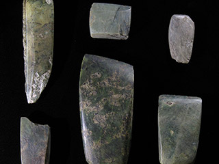 Six objets en pierre polie de formes rectangulaires avec un bord biseauté.