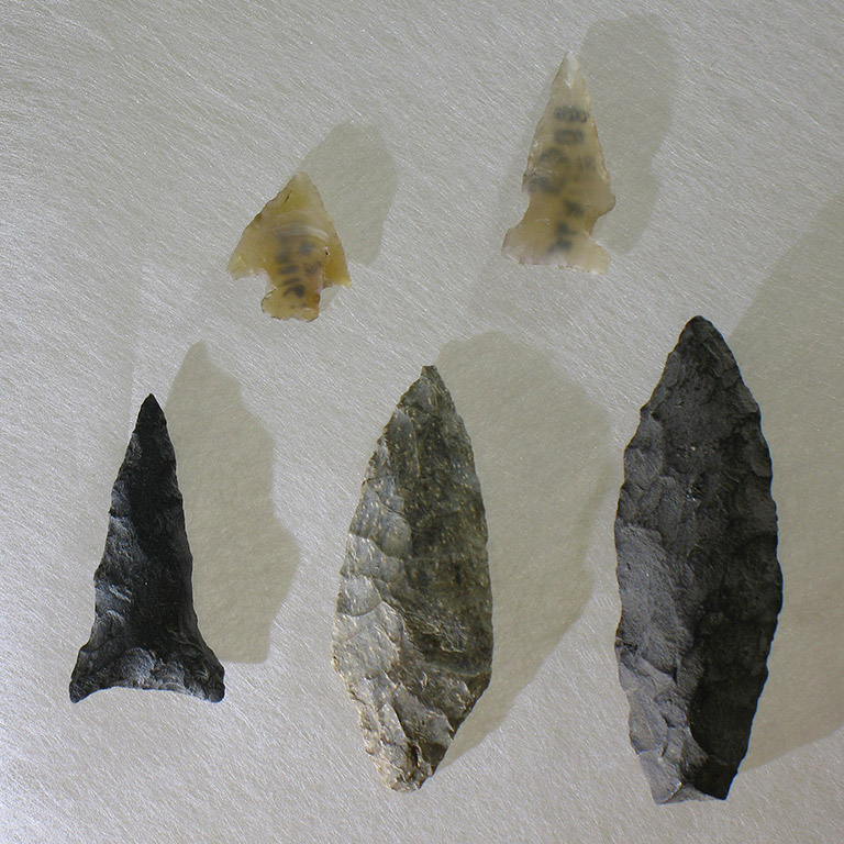 Five arrowheads of different shapes and materials.
