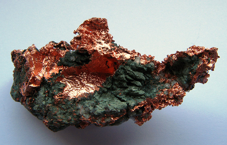 A deep copper orange object with dark grey chunks.