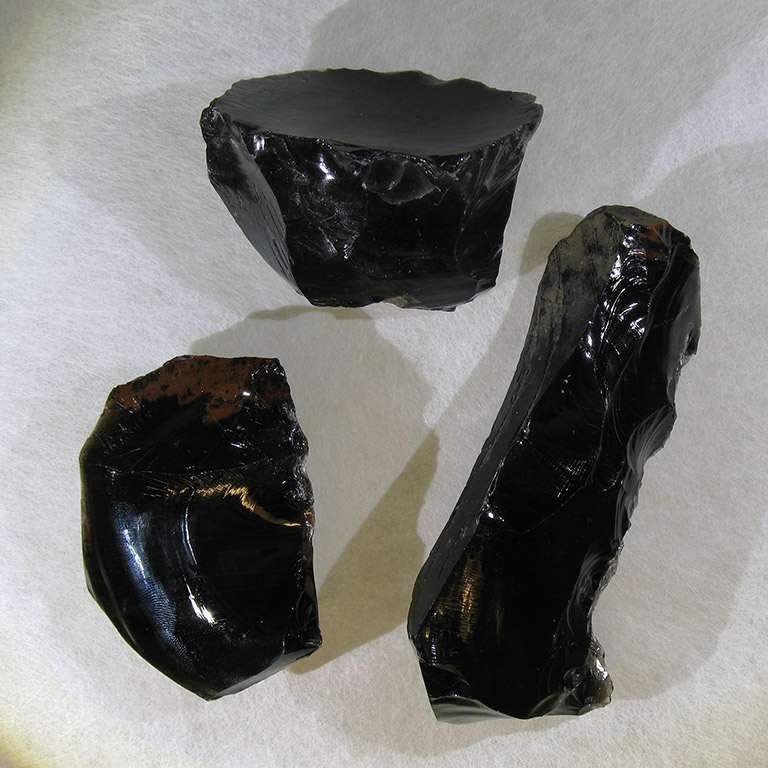Trois roches noires très luisantes.