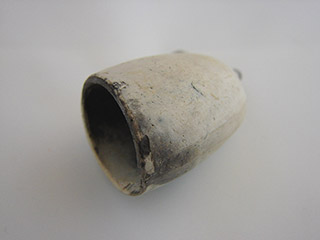 Smooth surfaced white hollowed cup shaped like a pipe bowl.