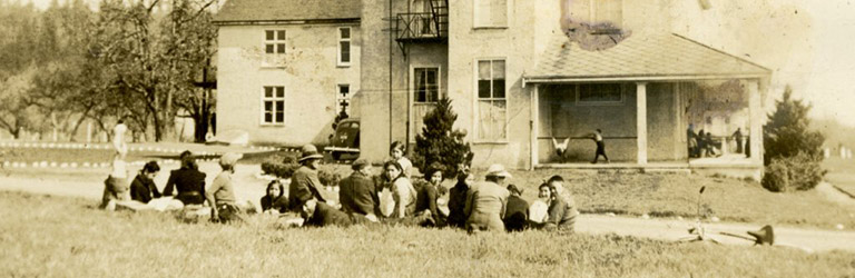 Photo noir et blanc d'enfants assis en face d'une maison historique